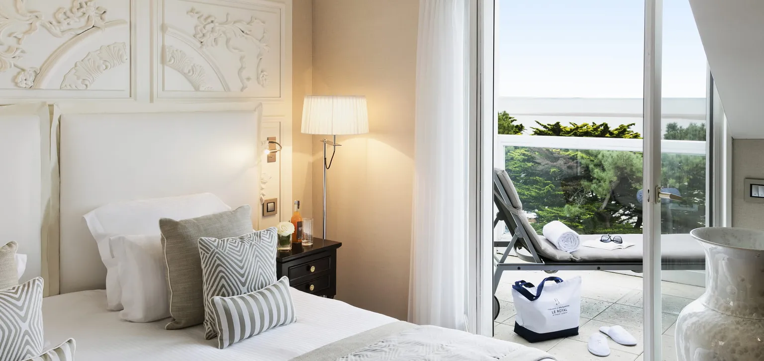 Lit avec vue sur la terrasse de la chambre Deluxe Mer de l'hôtel Le Royal La Baule