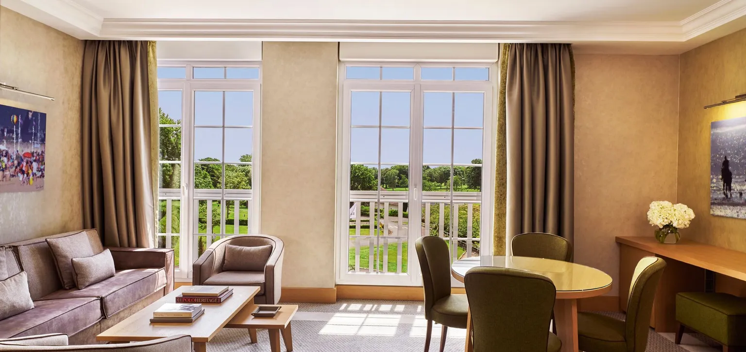 Suite Deluxe à l'Hôtel du Golf à Deauville avec vue sur le salon et l'extérieur
