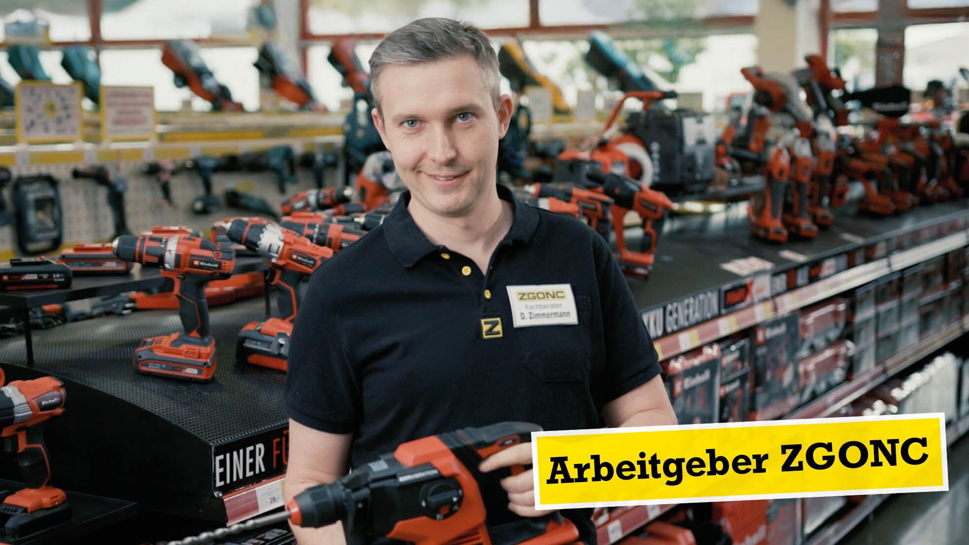 ZGONC-Fachberater hält einen Bohrhammer in der Werkzeugabteilung, umgeben von Elektrowerkzeugen.
