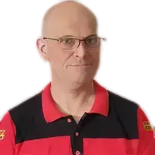 Kahlköpfiger Mann mit Brille trägt ein rot-schwarzes Poloshirt mit Logo, weißer Hintergrund.