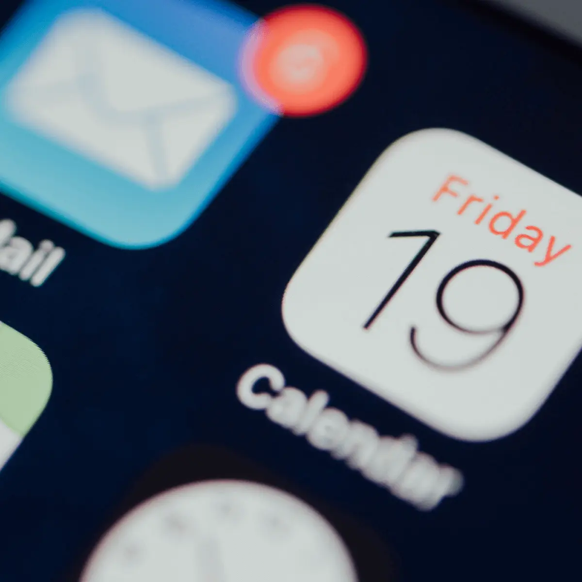 Close-up view of iPhone screen showing calendar app icon displaying Friday 19 date with notification badge