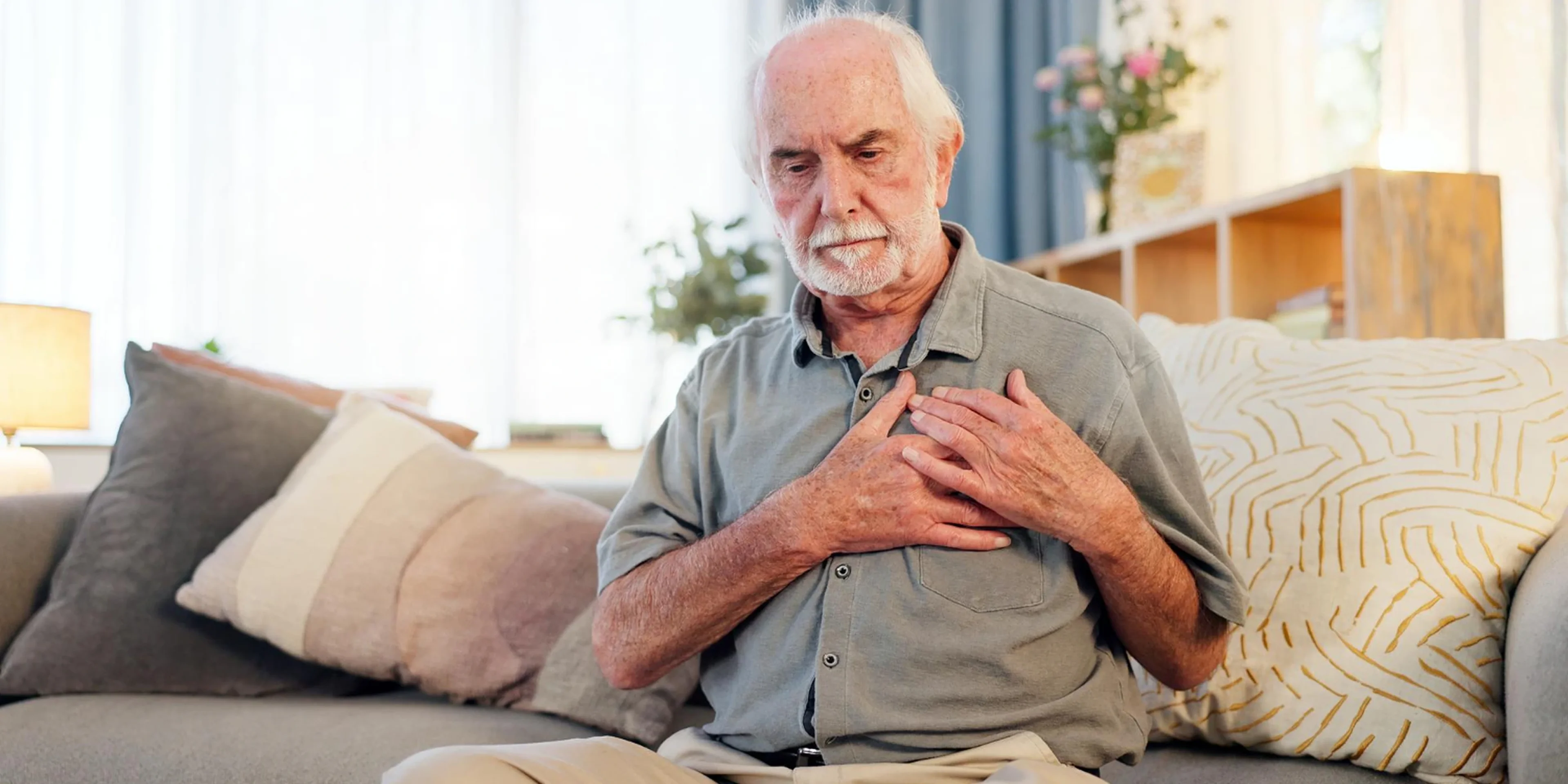 Ηλικιωμένος άνδρας με συμπτώματα καρδιαγγειακής νόσου κρατά το στήθος του με ανησυχία