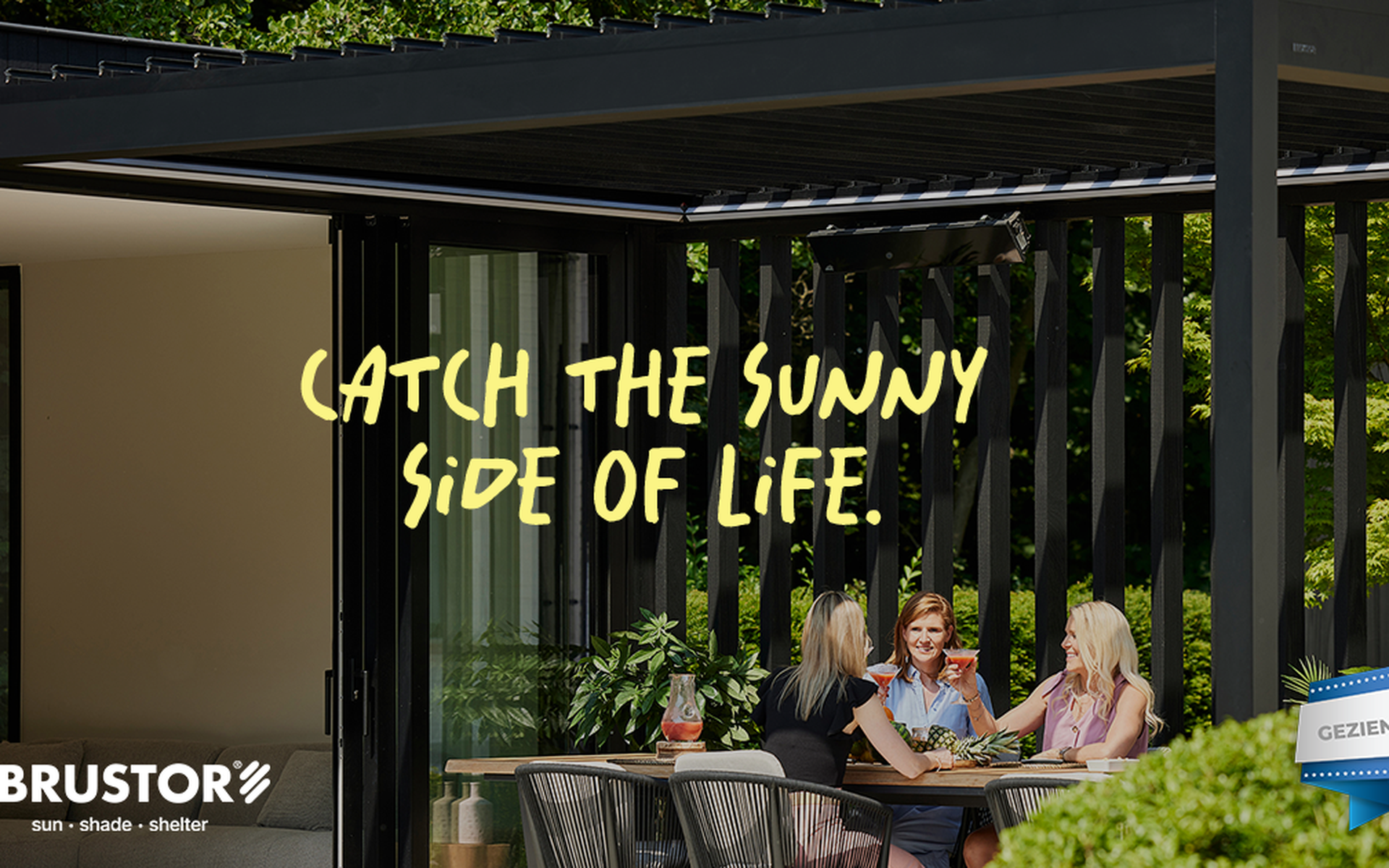 Terrasoverkapping met lamellen waar vier personen aan een buitentafel zitten onder een moderne aluminium pergola van Brustor, omringd door groen.