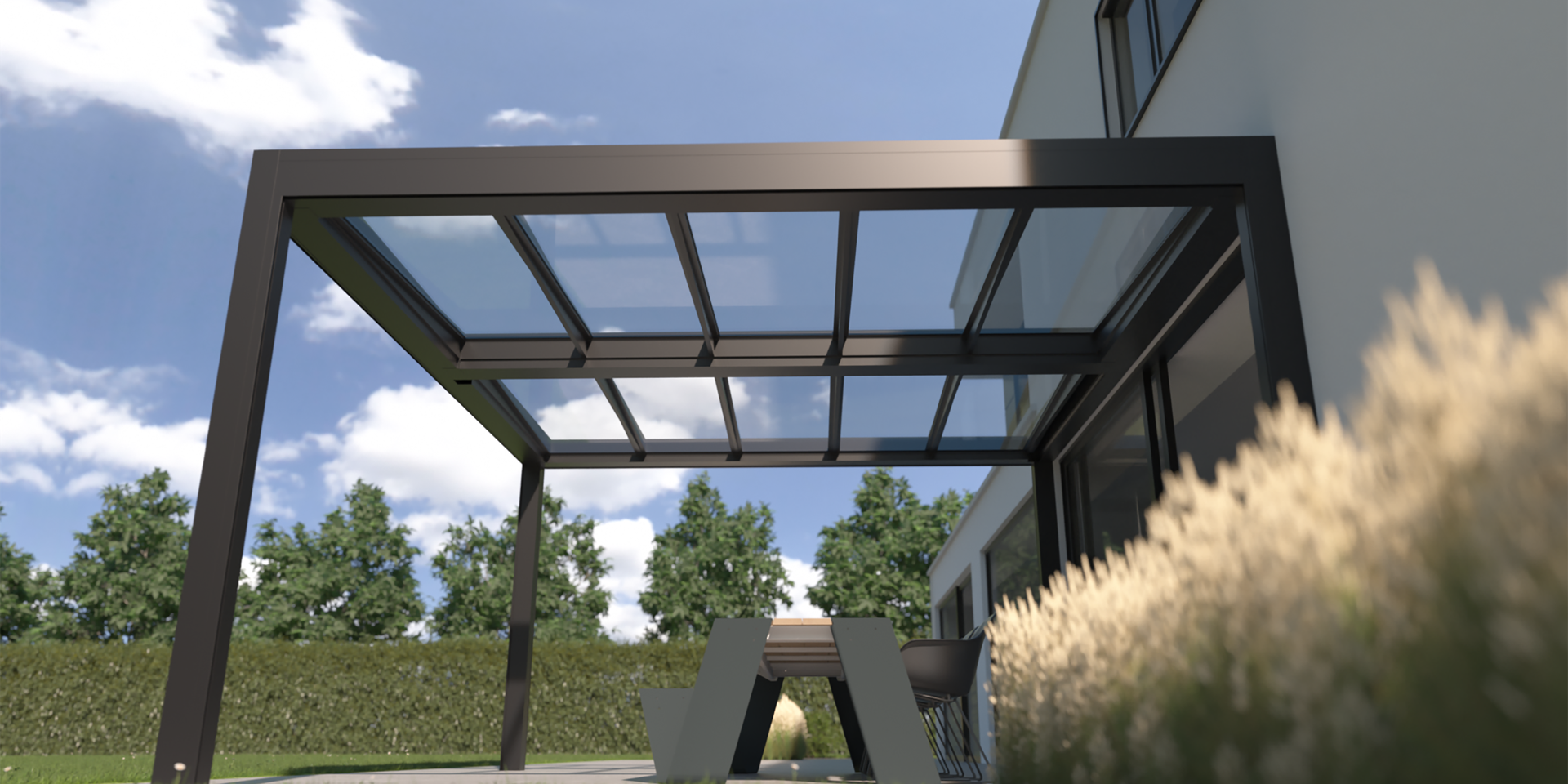 Pergola en aluminium avec toiture fixe en verre, adossée à une maison moderne et couvrant un espace repas extérieur sous un ciel dégagé.
