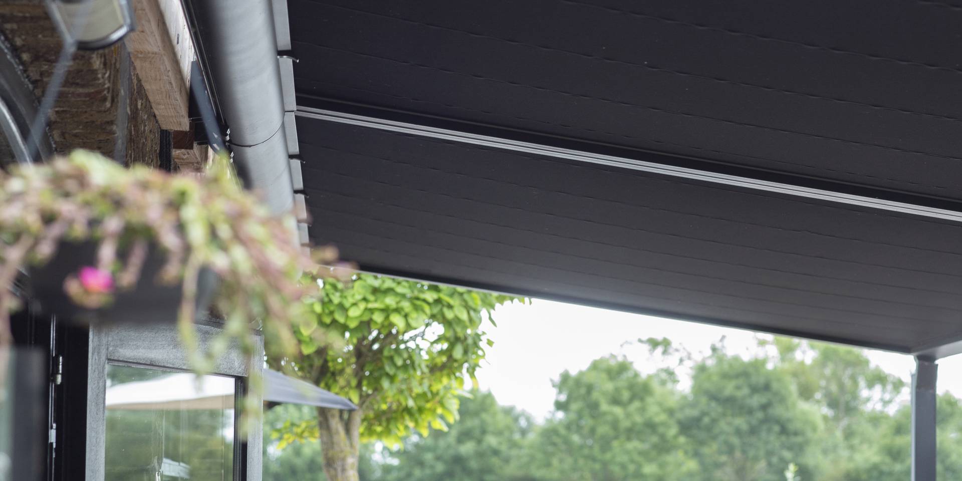 Nahaufnahme einer Brustor‑Pergola aus Aluminium mit ausfahrbarem Stoffdach, die langlebigen Sonnenschutz und einen stilvollen Schattenbereich bietet.