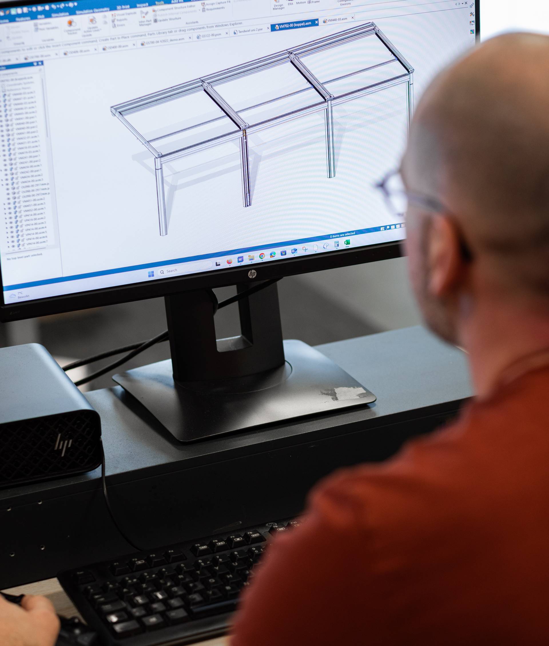 Hand die de cassette van een Brustor‑zonnescherm controleert tijdens de assemblage in de productieomgeving