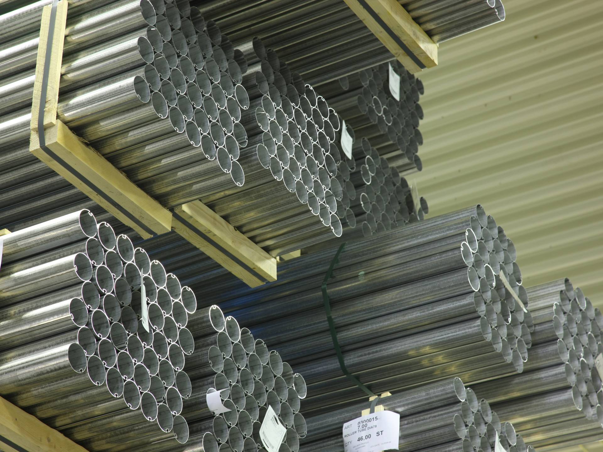 Stapels aluminium buizen opgeslagen op rekken in de productieomgeving van Brustor.