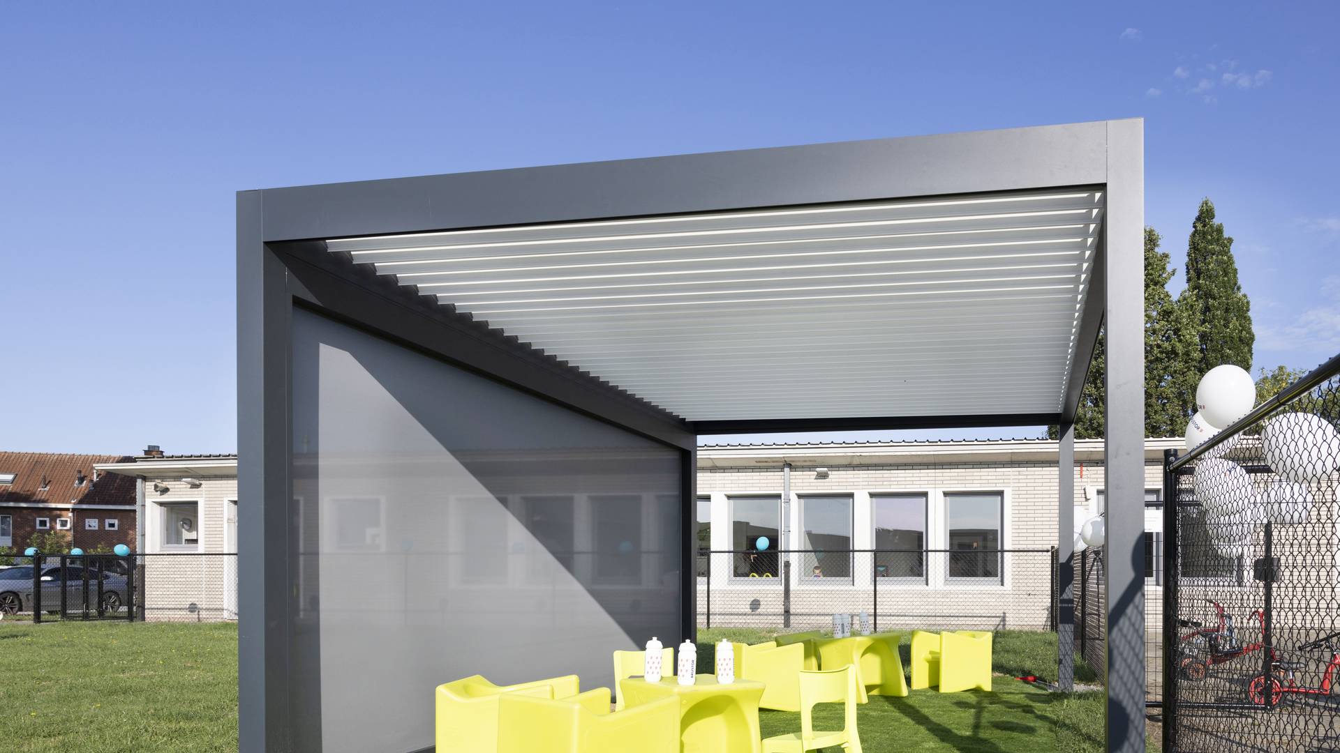 Aluminium‑Pergola mit Lamellendach und integriertem ZIP‑Screen, installiert in einem modernen Außenbereich für anpassbaren Sonnen- und Wetterschutz.