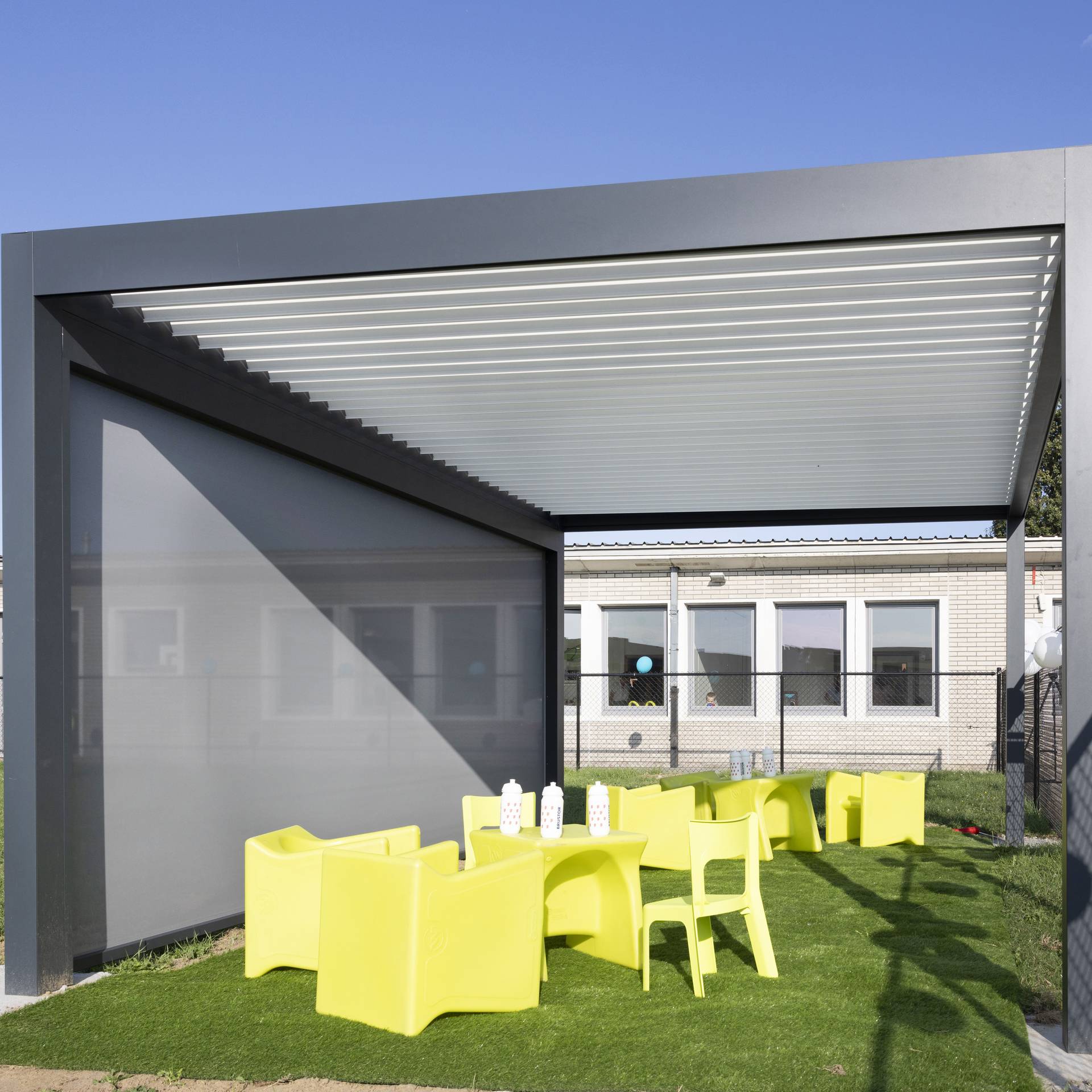 Aluminium terrasoverkapping met lamellendak en geïntegreerd ZIP‑screen geplaatst in een moderne buitenruimte voor regelbare schaduw en bescherming.