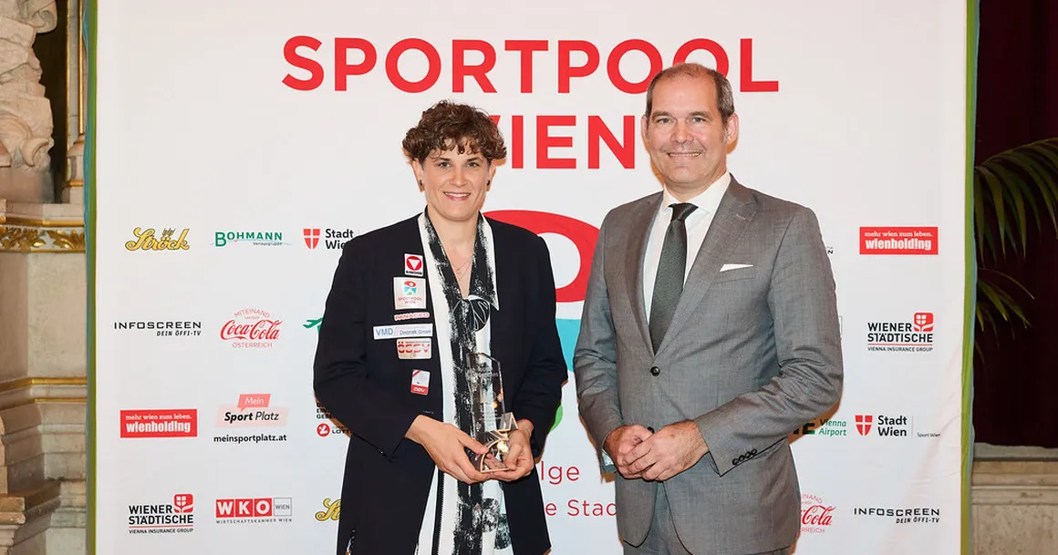 Ein Mann und eine Frau bei einer Preisverleihung für Sportlerinnen