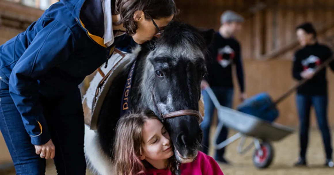 Eine Frau und eine Mädchen mit einem Pony