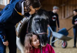 Eine Frau und eine Mädchen mit einem Pony