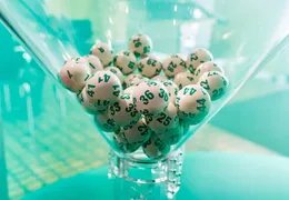Weiße Lotto Kugeln mit Grünen Zahlen  im Ziehungstrichter der Lotto Ziehung