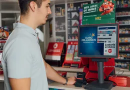 Ein junger Mann steht am Terminal bei einer Annahmestelle.