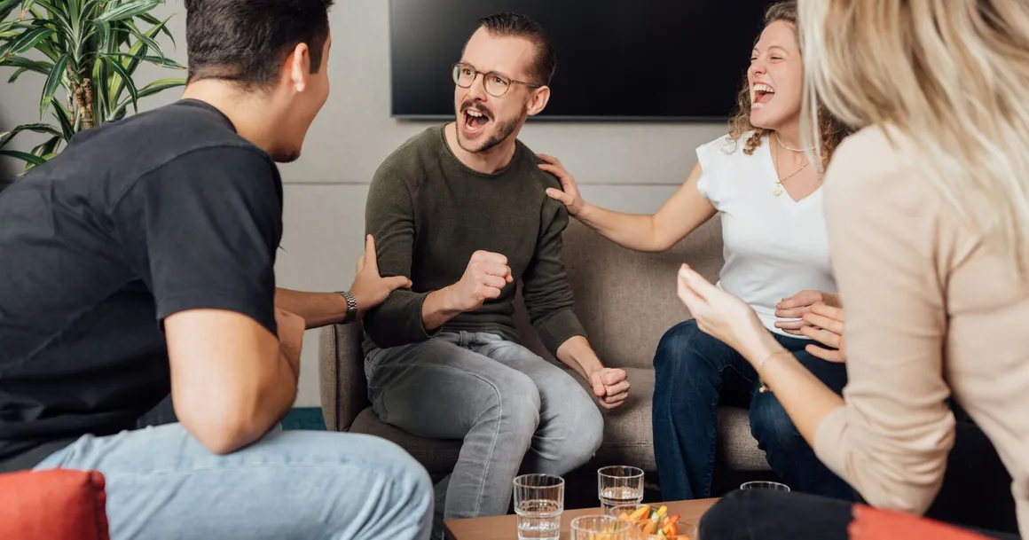 Vier Freunde freuen sich über einen Lotto Gewinn