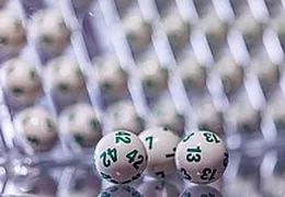 Im Vordergrund sind 3  Lotto Kugeln abgebildet. Im Hintergrund sieht man Lotto Kugeln unscharf.