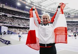 Natalija Eder freut sich und hält die Österreich Fahne in die Höhe