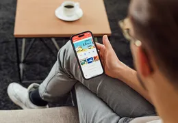 Ein Mann schaut auf Sein Handy auf der er eine App geöffnet hat