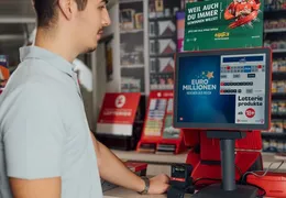 Ein junger Mann steht am Terminal bei einer Annahmestelle.