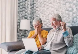 zwei ältere Personen freuen sich über einen Gewinn