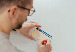 Jemand füllt einen EuroMillionen Wettschein aus.
