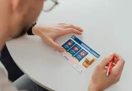 ein junger Mann füllt einen EuroMillionen Anteilsschein aus
