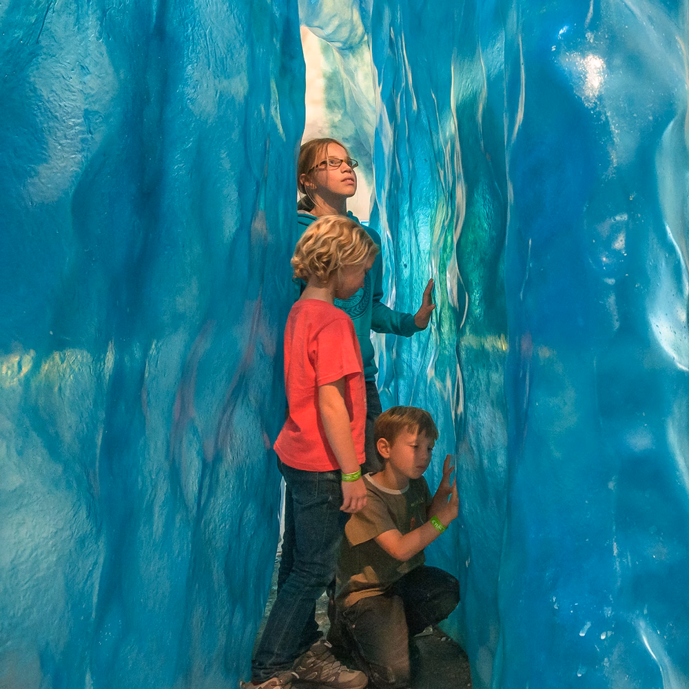 kids exploring an ice cave exhibit with glacier walls