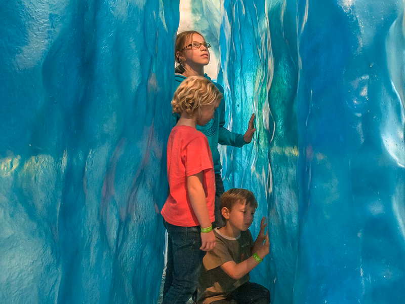 kids exploring an ice cave exhibit with glacier walls