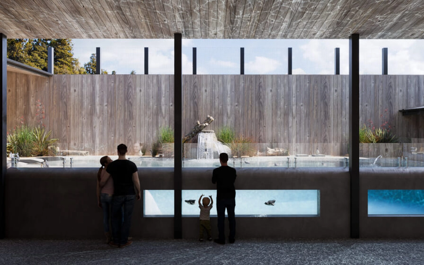 People viewing aquatic exhibits through glass panels in a modern, open-air wooden structure with natural lighting.