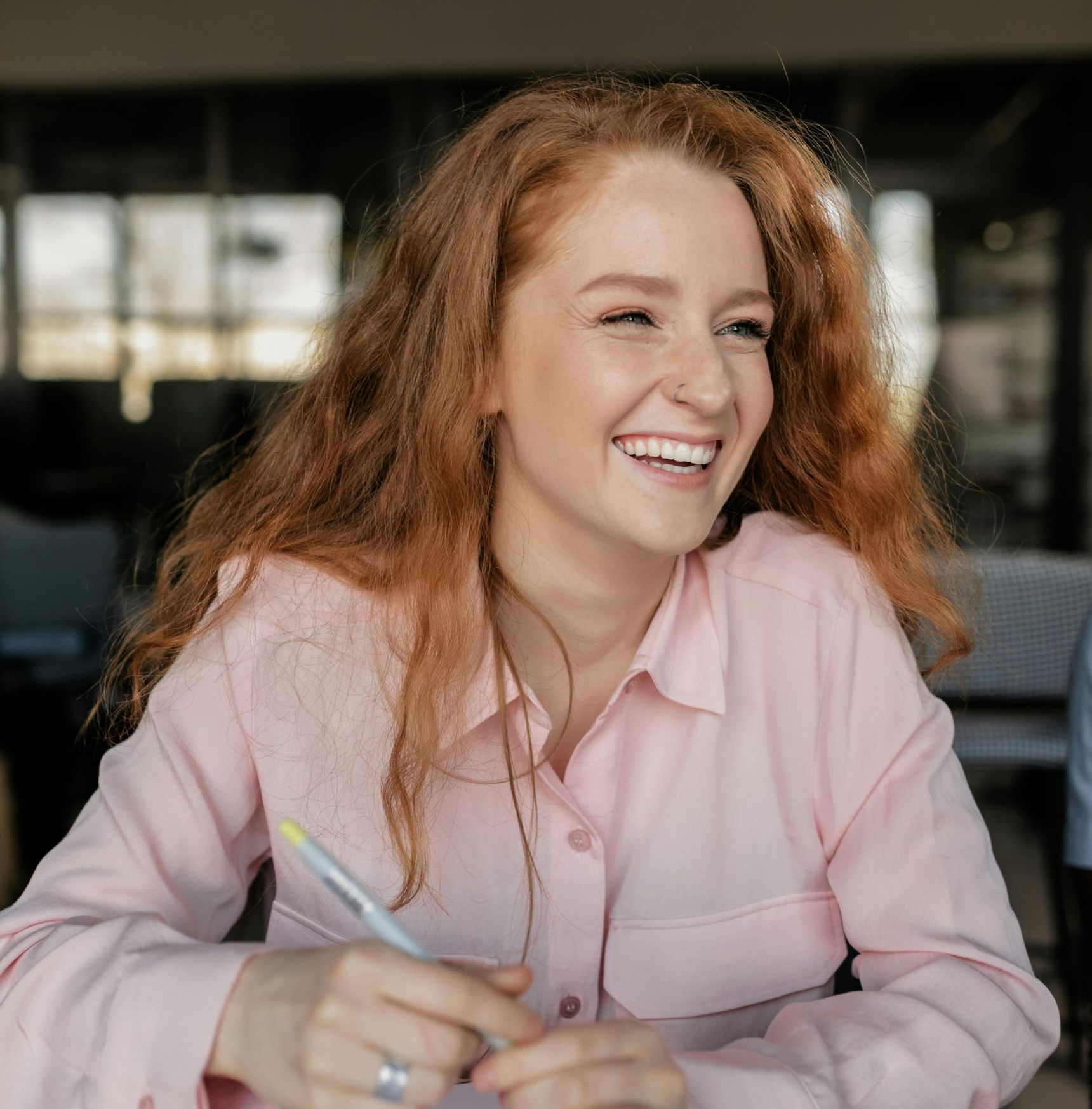 Happy HR professional smiling while working, representing human-centered, data-driven HR analytics.