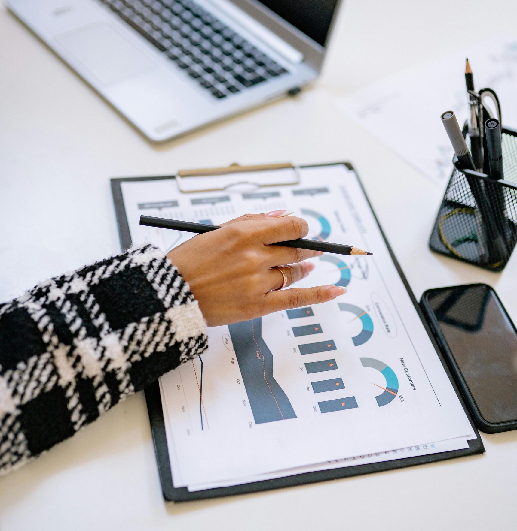 Consultant pointing at data visualization graphs on paper during a data-driven decision scan, supporting actionable analytics and smarter business decisions.