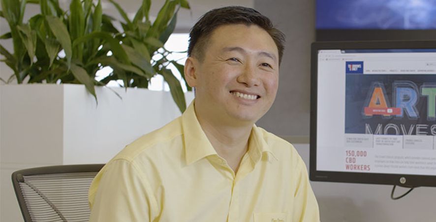 Liem Ngo smiling at his desk