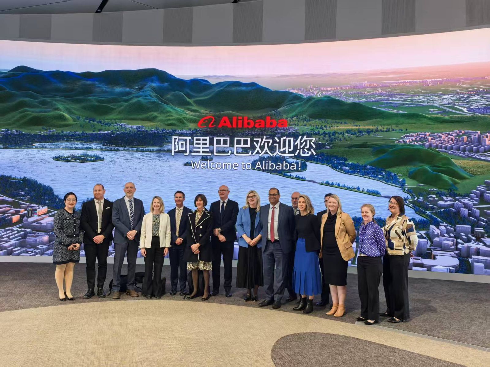 ANZSOG China Reciprocal Program delegation standing in front of a large 'Welcome to Alibaba' screen
