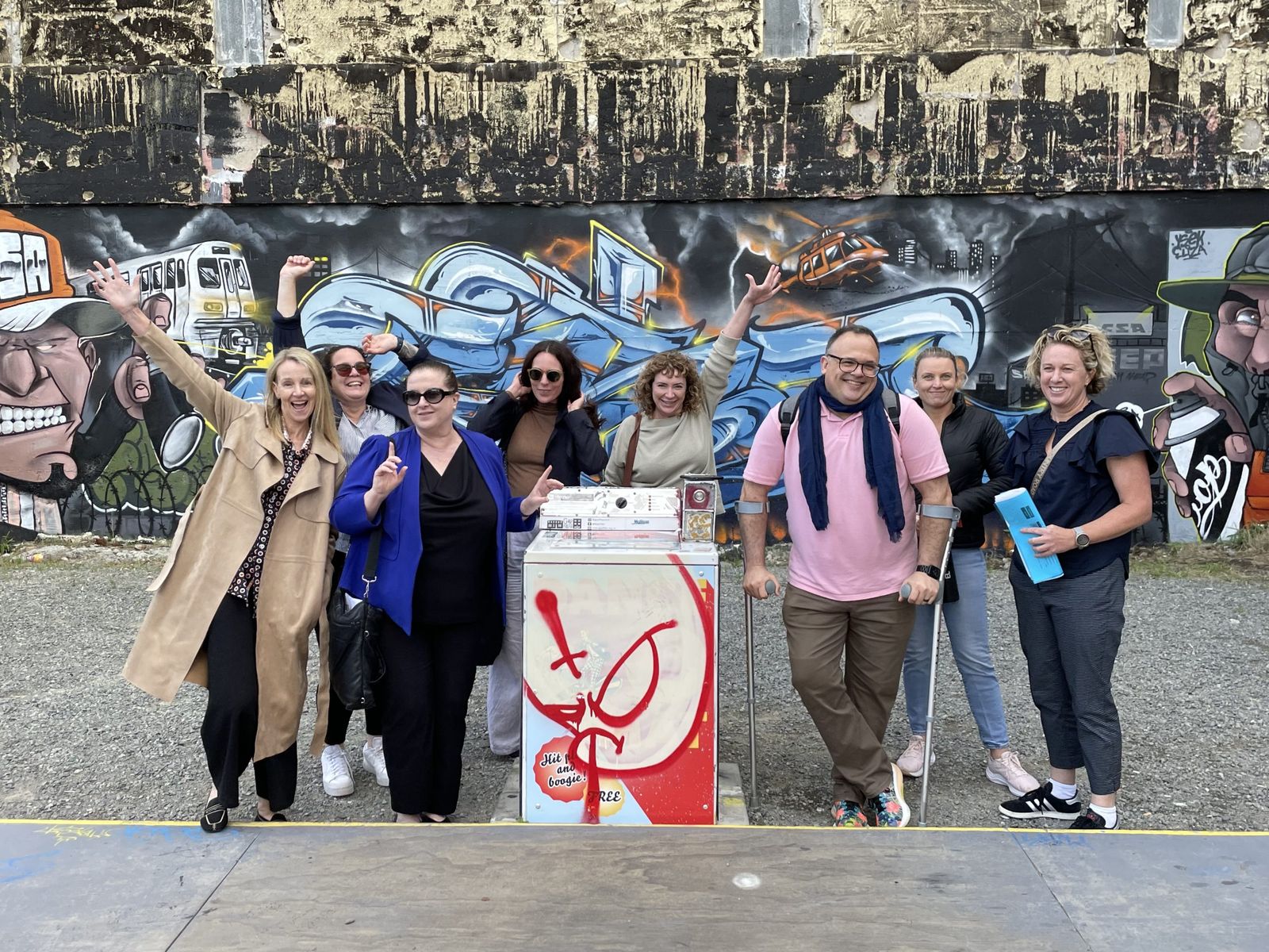 Executive Master of Public Administration students posing in front of a graffiti mural in Christchurch