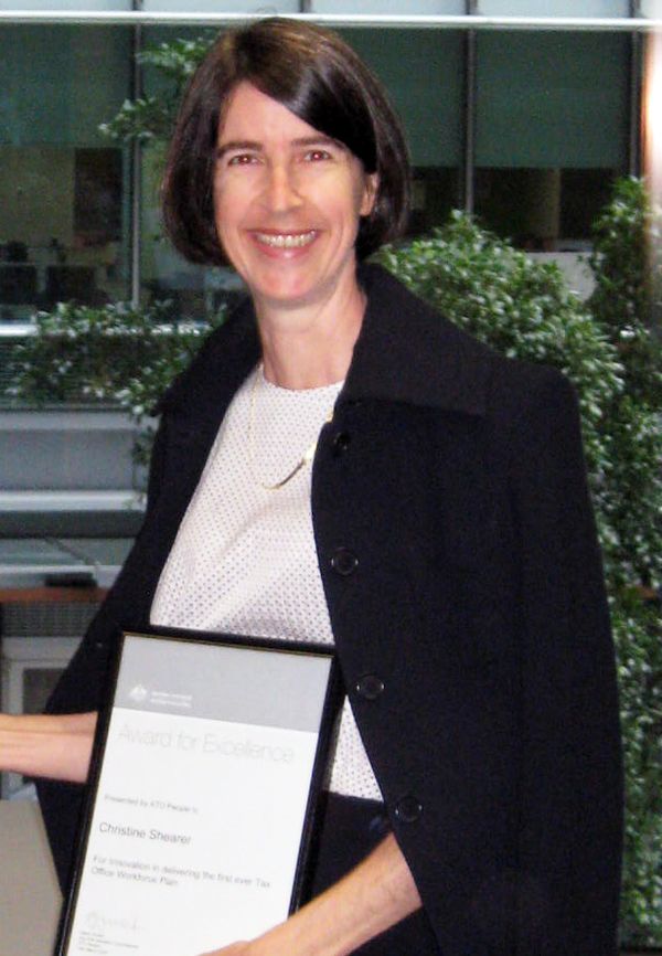 Christine Shearer holding an Award for Excellence certificate