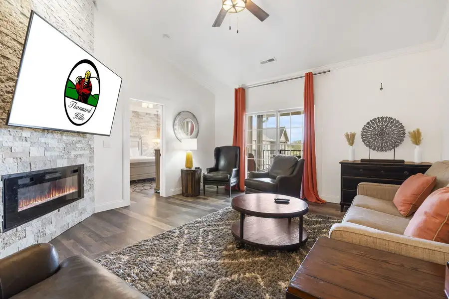 Modern living room with fireplace, comfortable seating, and scenic views from large windows.
