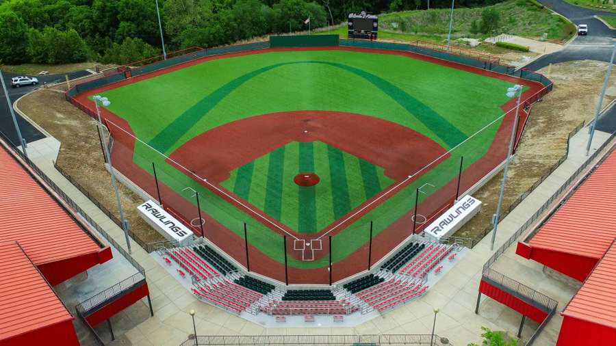 Aerial view of a baseball stadium with red seating, green outfield, and red infield dirt.