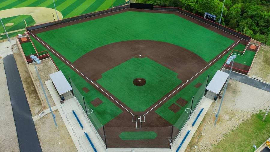 Overhead view of a well-maintained baseball field with green outfield and brown infield dirt.