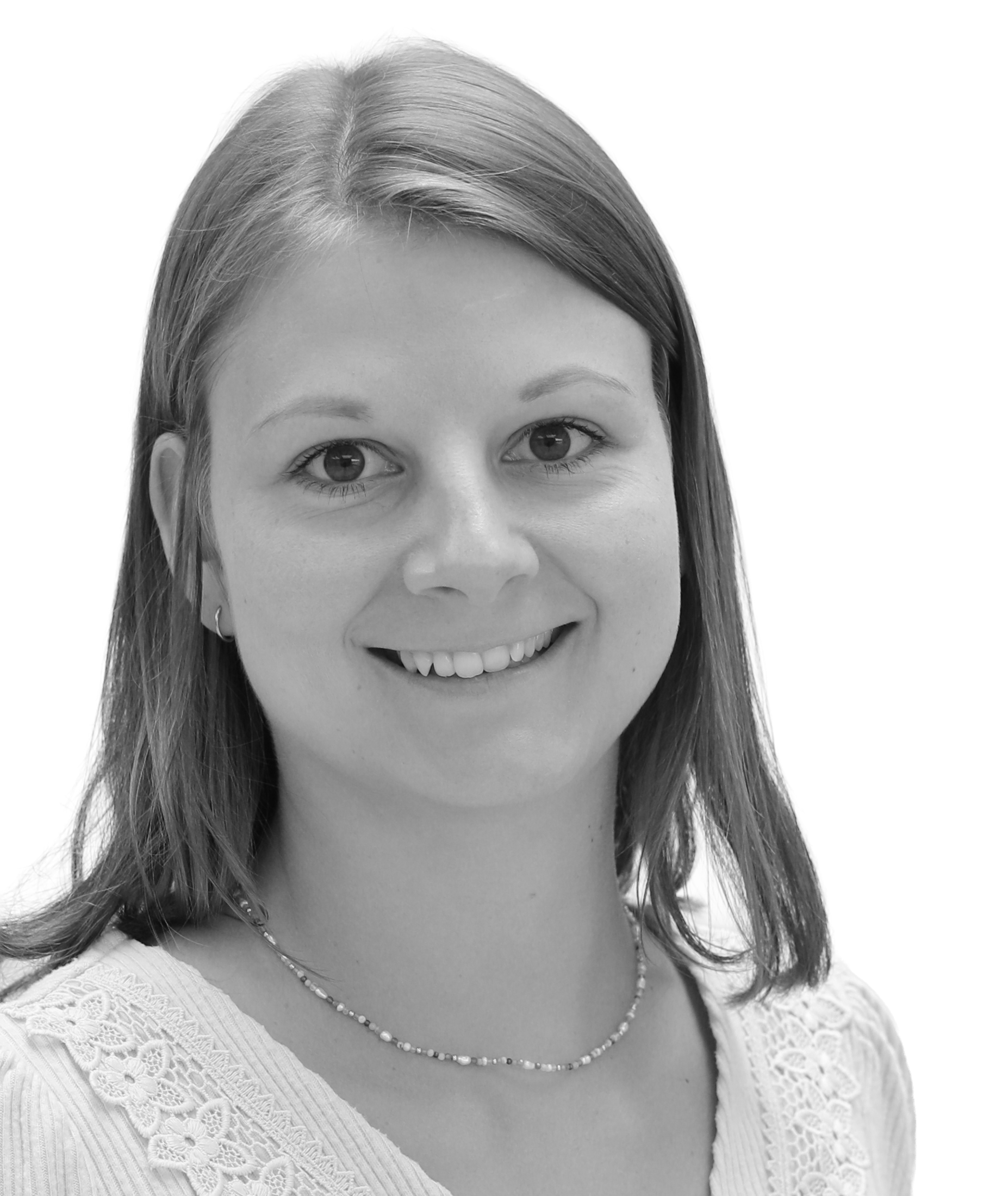 A grayscale portrait of a woman with straight hair, wearing a lace-trimmed top and a delicate necklace, smiling at the camera.