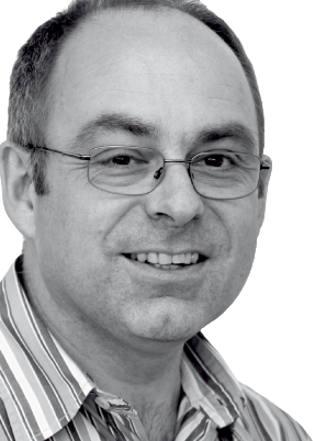 Smiling man with glasses and a striped shirt, facing forward.