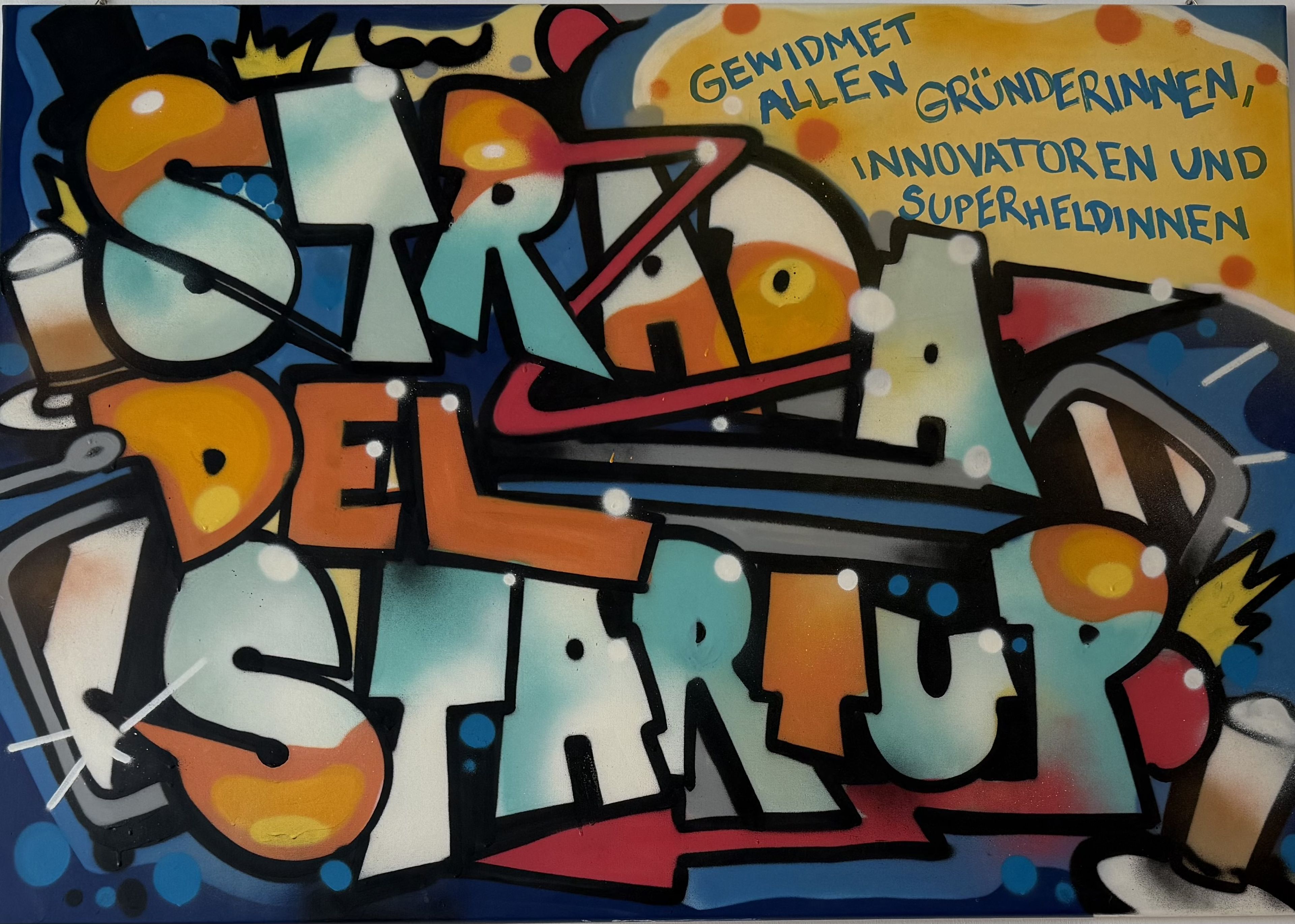Colorful graffiti-style mural with text "Straße der Startup" and a message dedicated to founders, innovators, and superheroes in German.