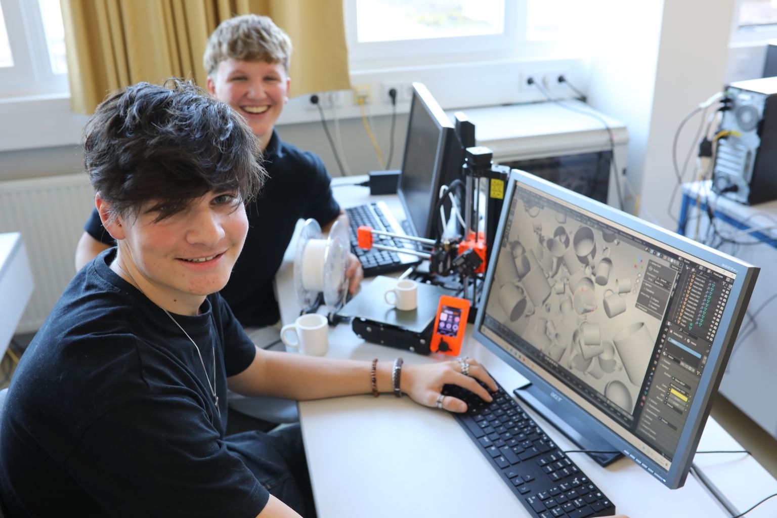 Zwei Burschen vor PCs