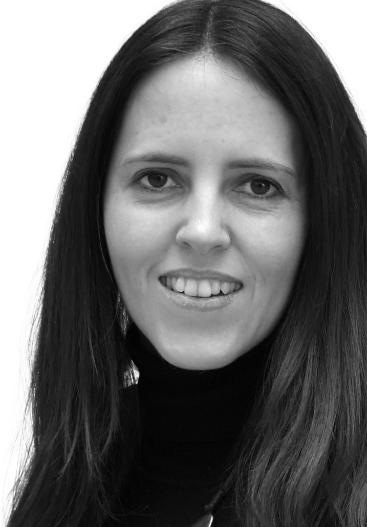 Black and white portrait of a woman with long dark hair, smiling slightly, wearing a black turtleneck.
