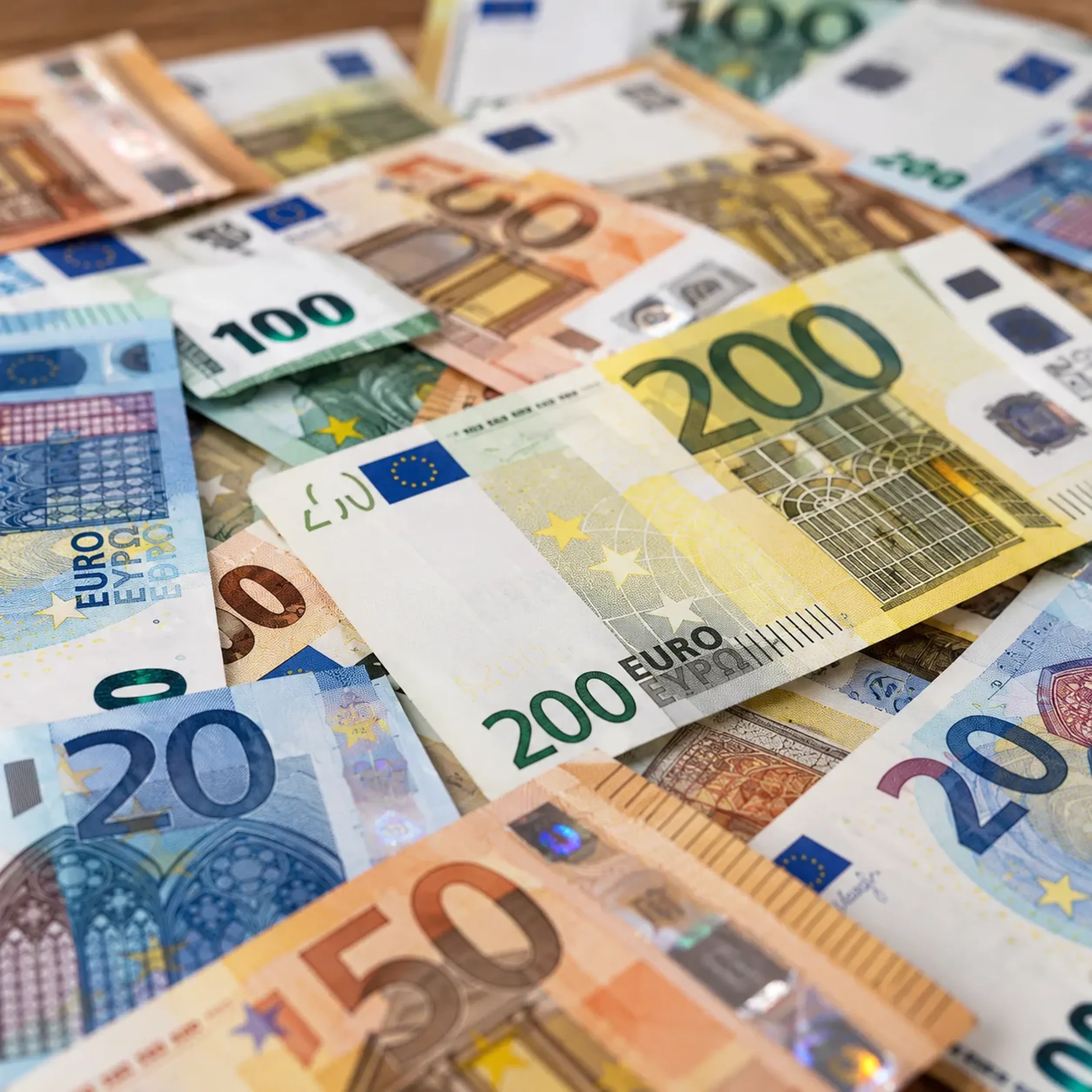 Verschiedene Euro-Banknoten in unterschiedlichen Nennwerten liegen übereinander verstreut.