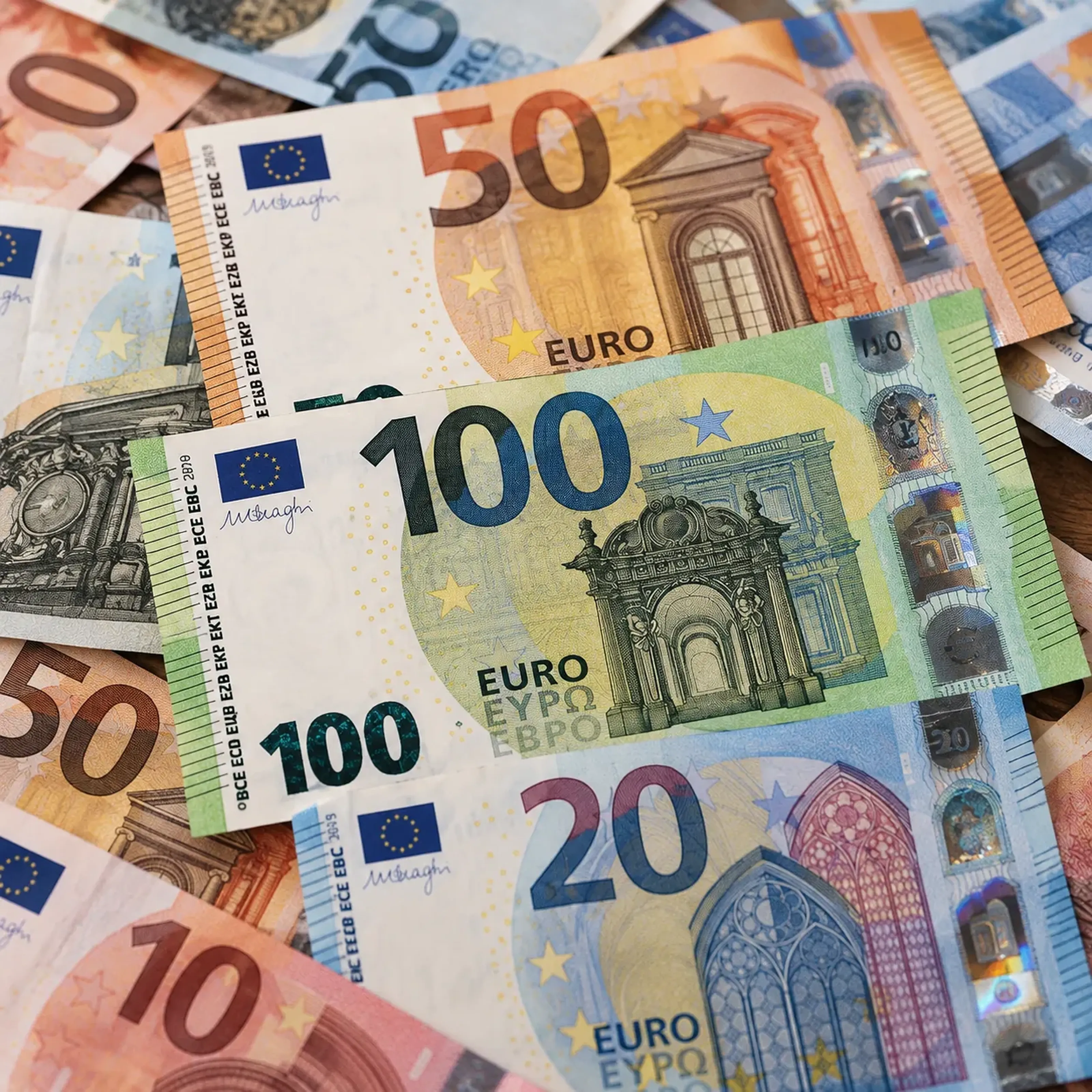 Verschiedene Euro-Banknoten, darunter 100, 50 und 20 Euro, liegen übereinander auf einem Tisch.