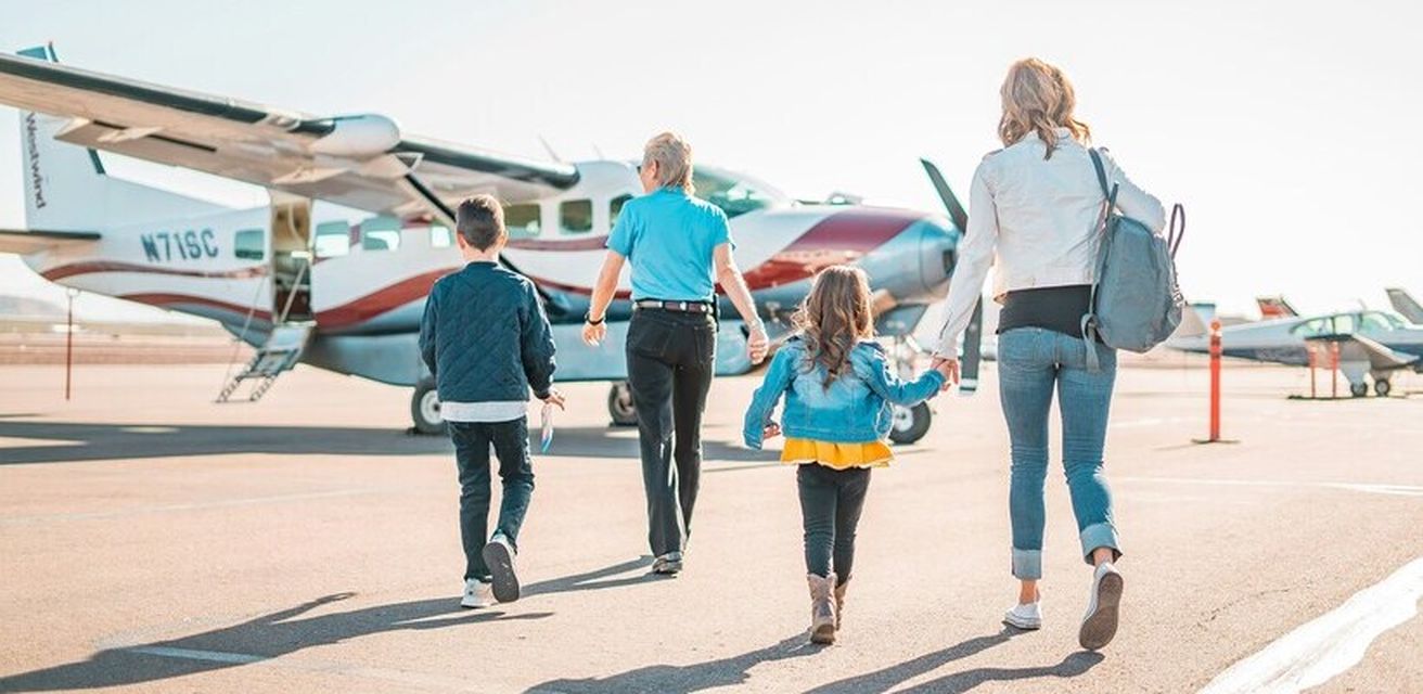 Eine Familie steht auf dem Flugplatz mit dem Rücken zur Kamera gedreht