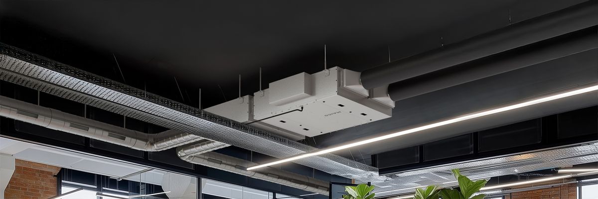 Weiße, rechteckige Deckenlüftungsanlage mit sichtbaren Lüftungskanälen und LED-Lichtleisten in modernem Büro.