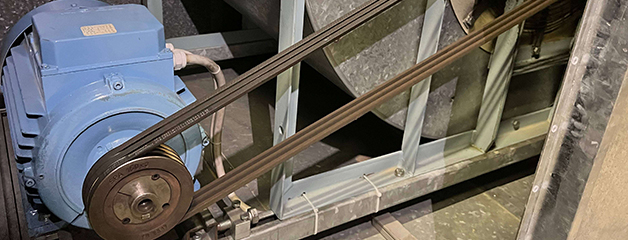 Blue electric motor with two V-belts attached to a metal frame