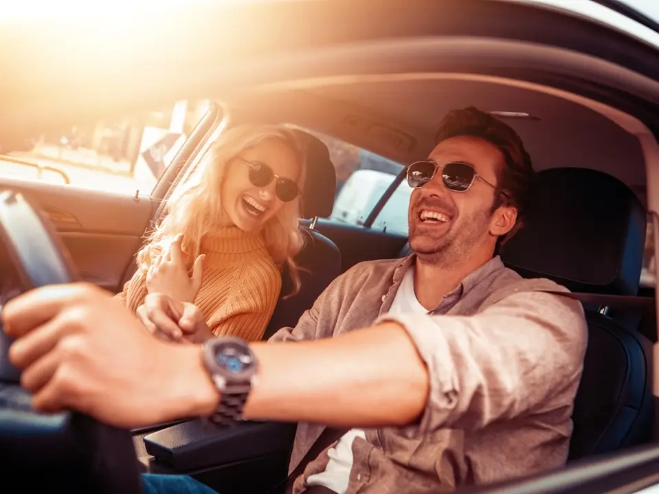 Pärchen im Auto auf den Weg in den Urlaub