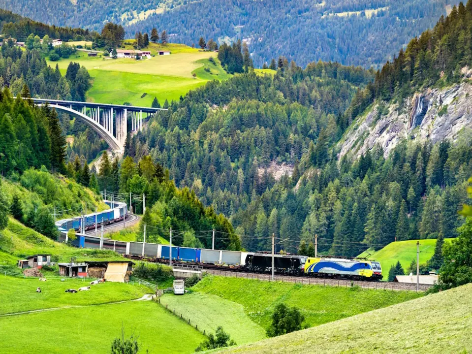 Autobahnbrücke am Brenner mit Güterzug im Vordergrund